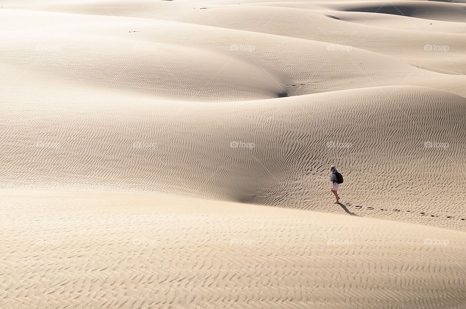 A small person walking alone in desert
