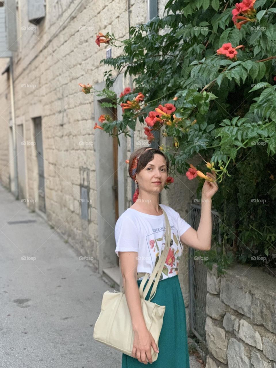 Portrait of a woman in summer, old town, flowers 