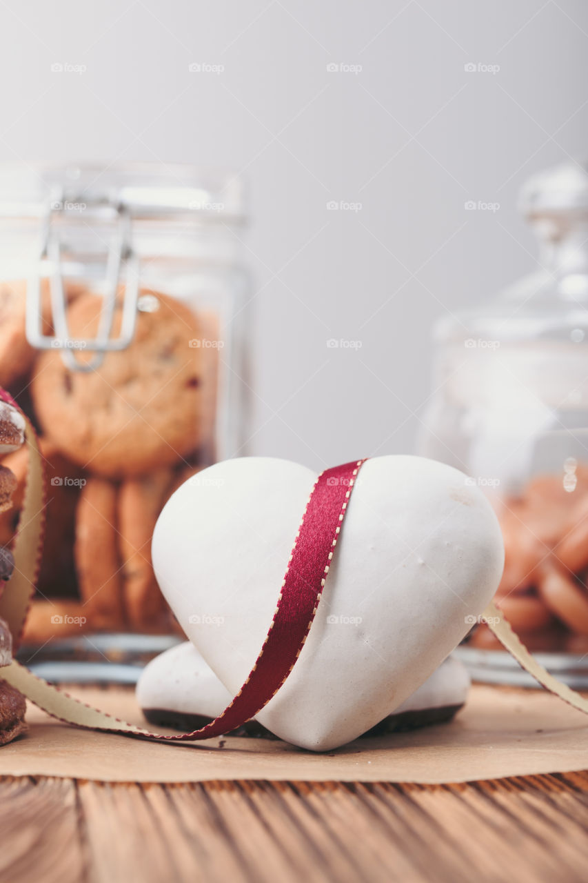 Gingerbread cookies, candies, cakes, sweets in jars on wooden table