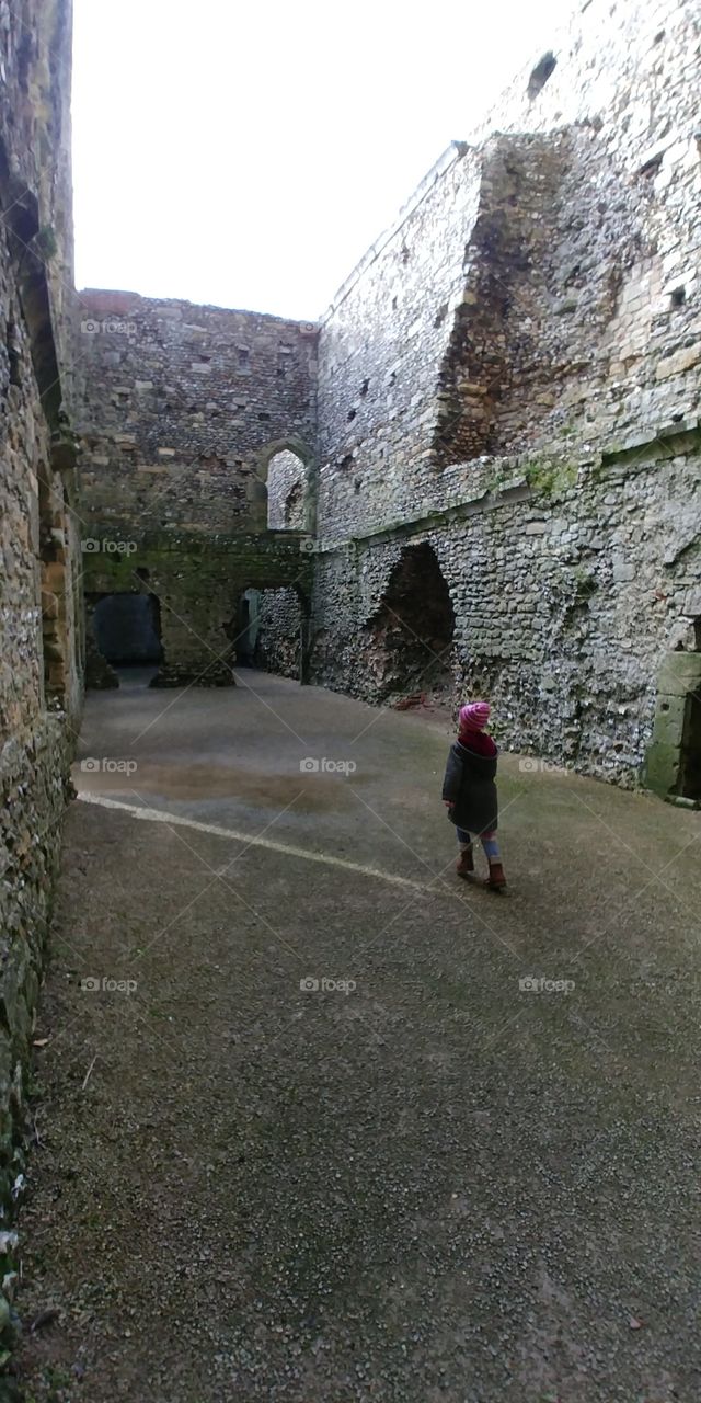 little girl wandering through ruins of castle