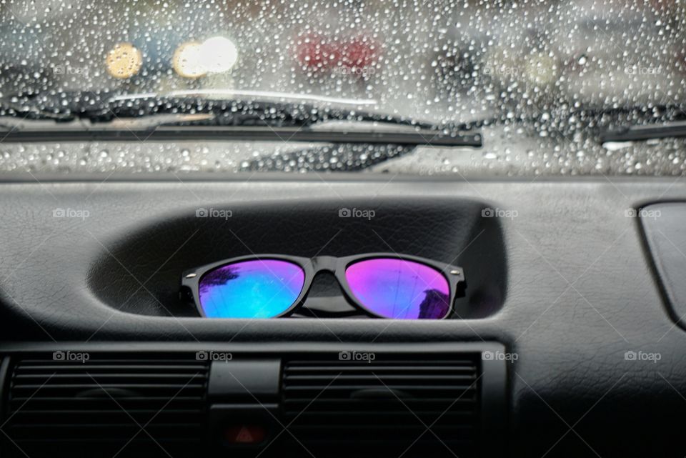 Eye Glasses on a Dashboard of a Car in Rainy Weather