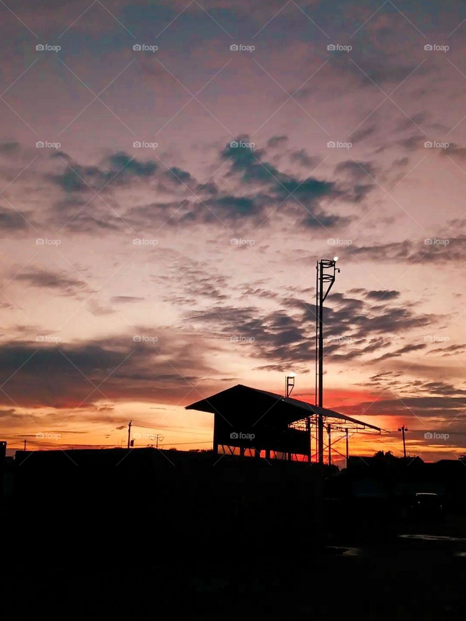 Portrait of the silhouette of buildings and lampposts against a beautiful sky background at sunset, creating gradations of orange and blue