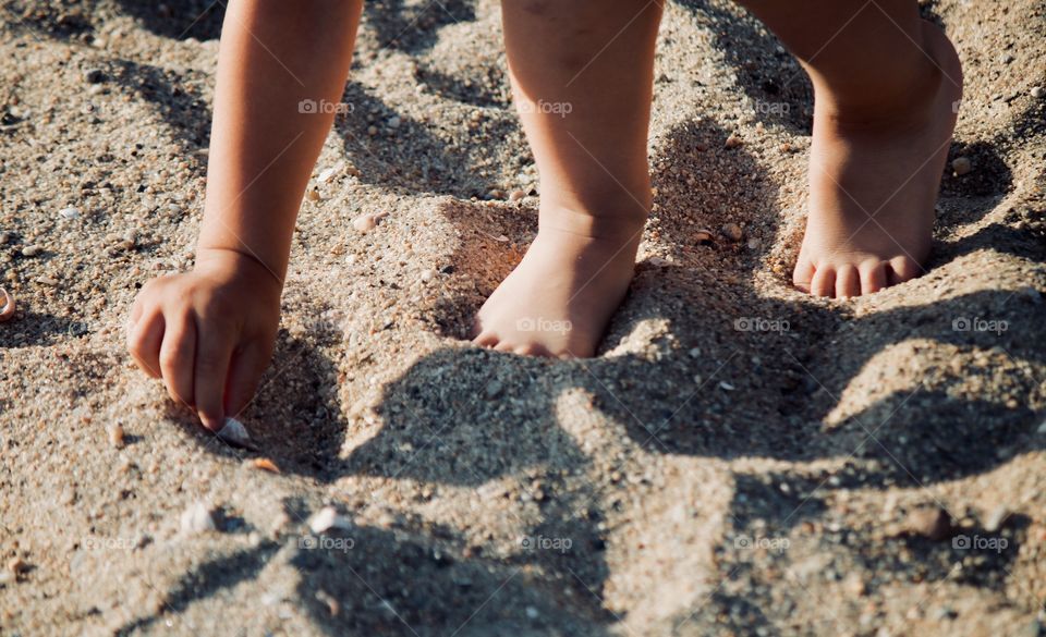 Child on the beach picking sea shells 