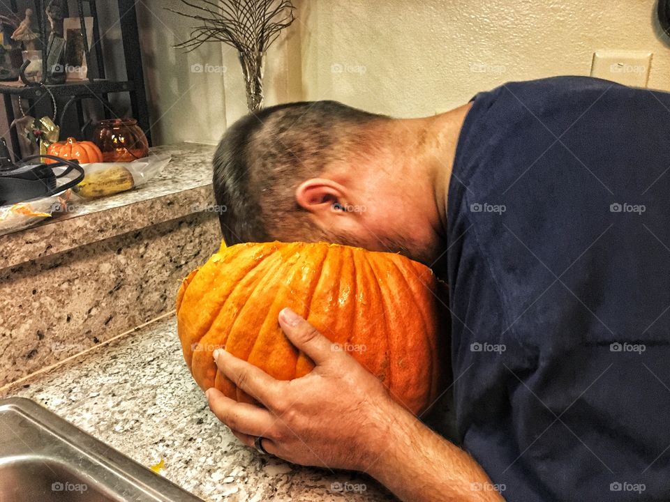 Pretending the pumpkin is eating him 