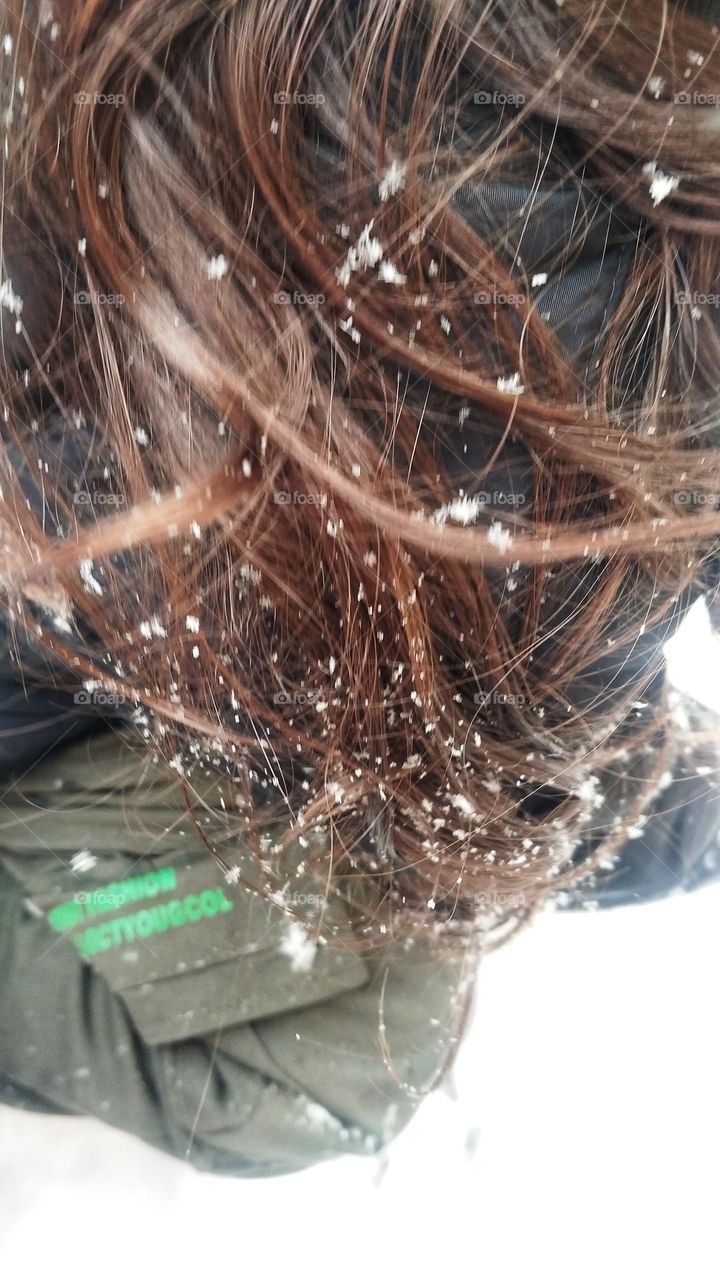 While he is making snowball ,first snowflakes of the city dance happily on the long hair of the little angel