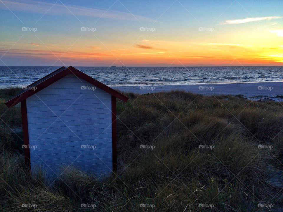 Lonely beach hut in sunset