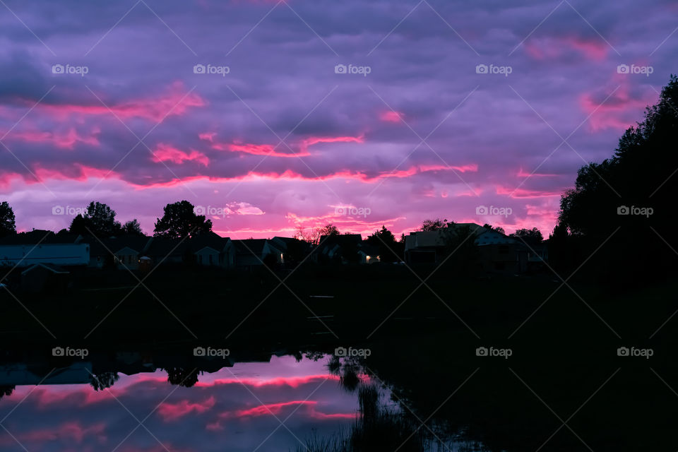 Sunset by a pond with purple and pink sky. 