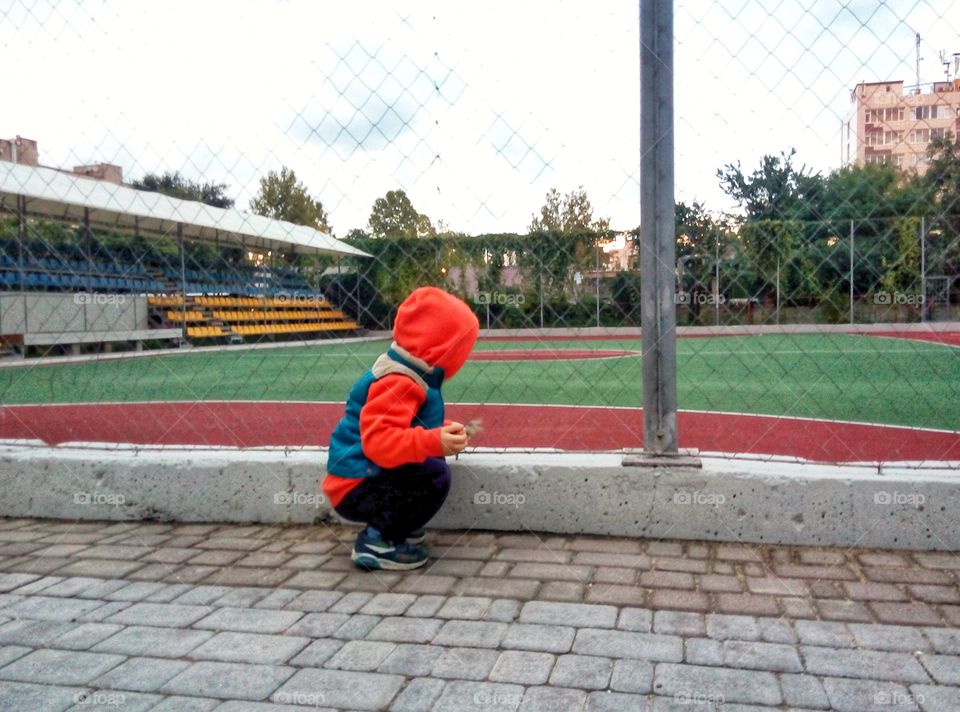 baby near the sports field малыш возле спорт  площадки