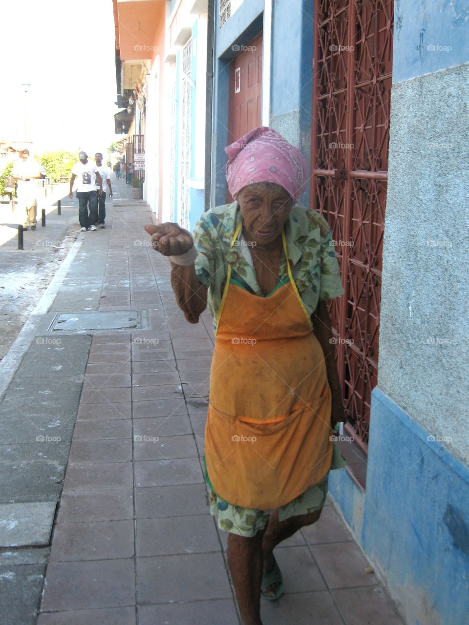 Old Woman Begging. On the streets in Nicaragua begging, and being followed by a group of men. The reason unknown. Thugs? Protectors?  I'll never know....