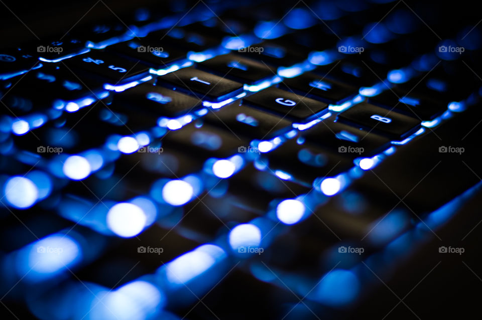 Glowing laptop keyboard . Close up of a Mac laptop keyboard glowing in the dark