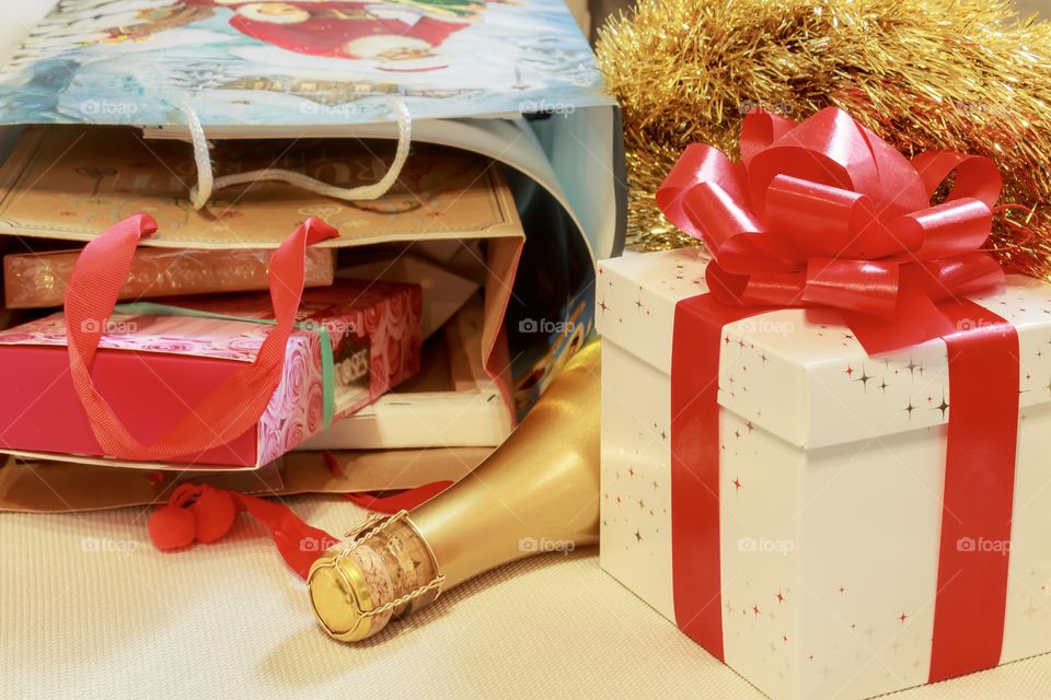 Christmas gift - a box with a ribbon, champagne and a bag of sweets and candies