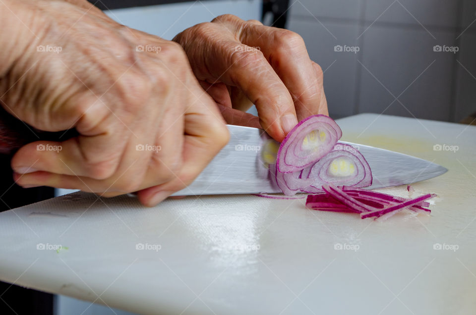 slicing a red onin to add a salad.
