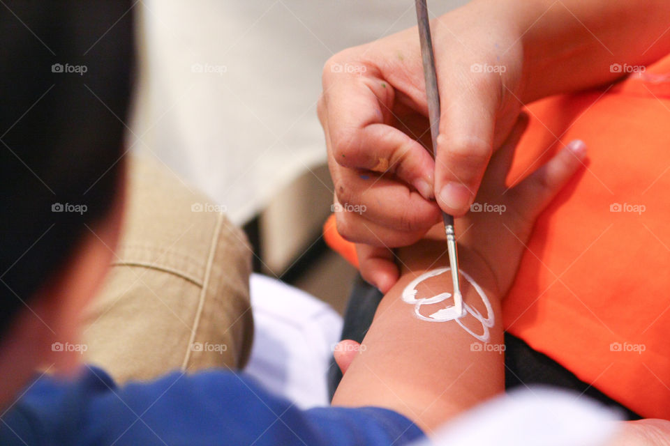 body painting artist paints an arm of a person