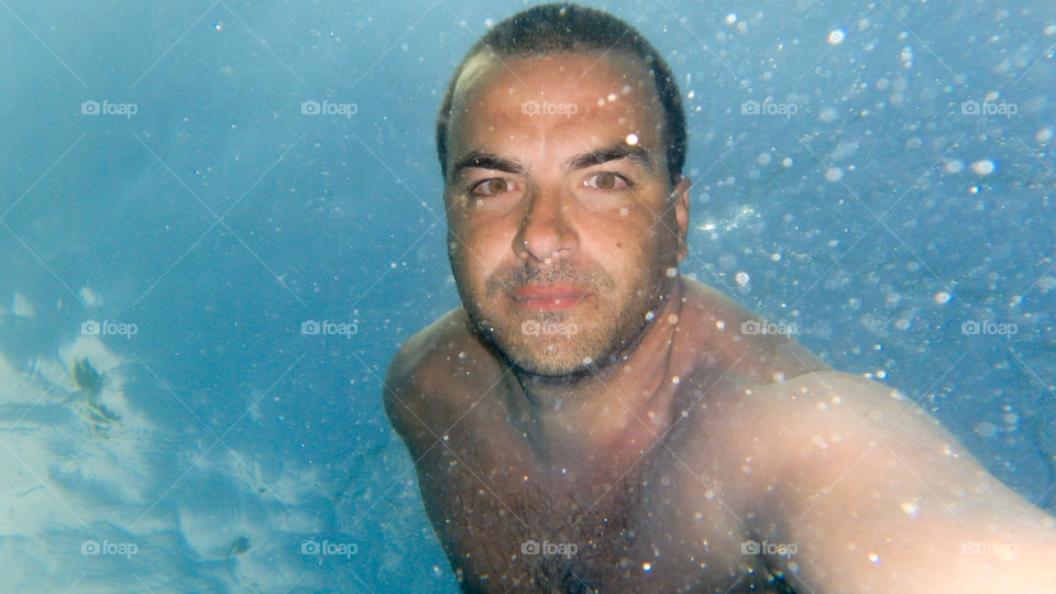 young man portrait underwater, diving and swimming