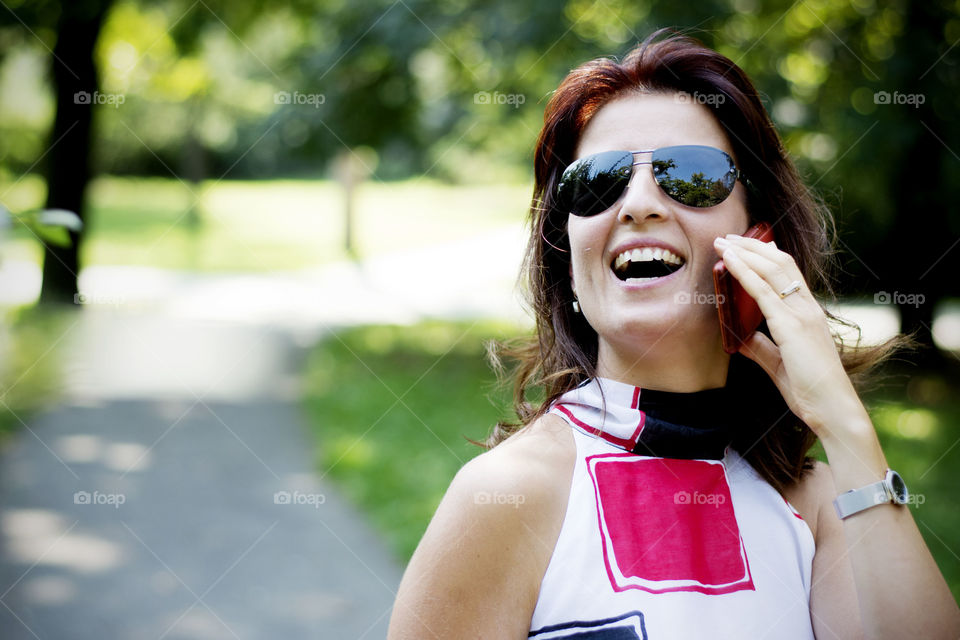 Portrait of a young happy woman talking on mobile phone