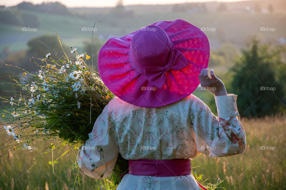 Lady in a pink hat looking at sunset