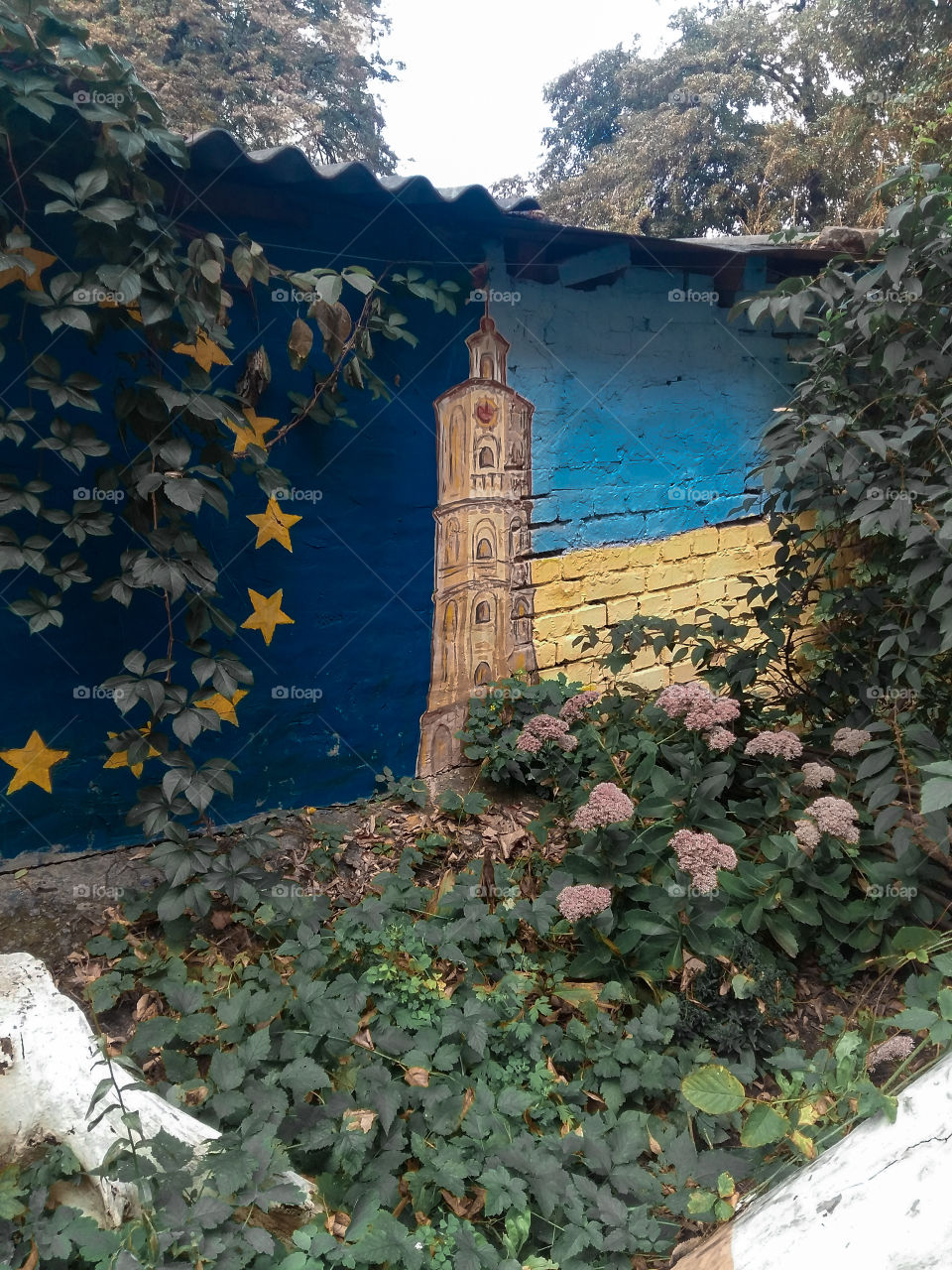 graffiti tower on a brick wall with flags of Ukraine and the European Union