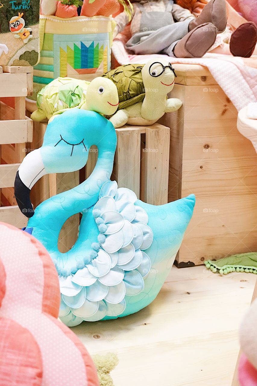 Details of nursery playroom for children with selective focus on the blue flamingo soft plush pillow.