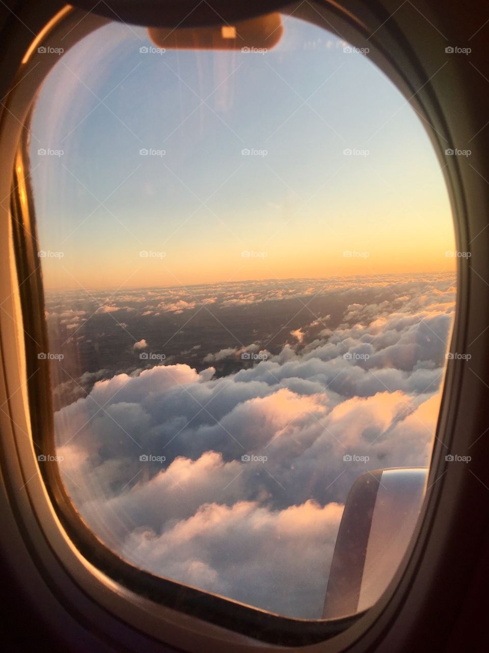 Looking out at the sky at sunrise from an airplane window 