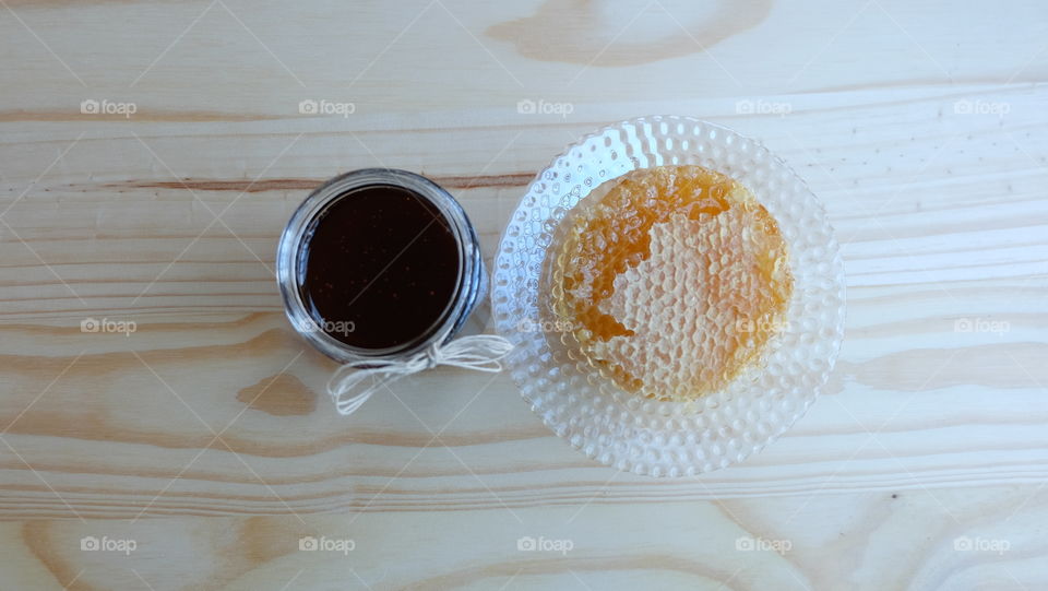 Honey comb and honey on a wood background