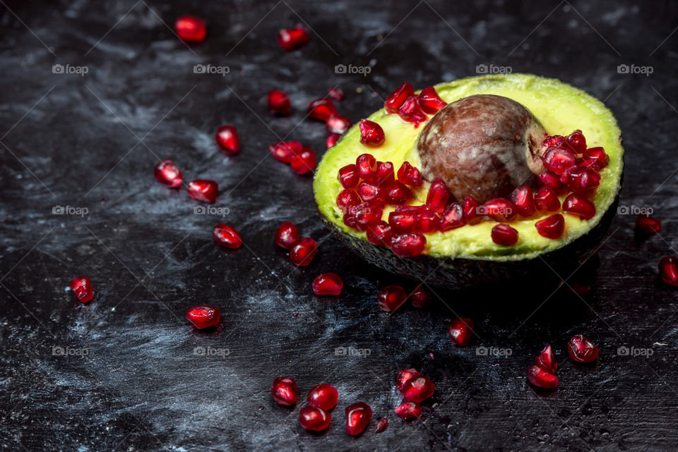 seductive pomegranate red seeds on avocado