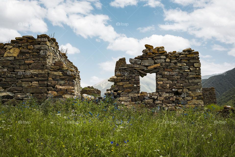 Ancient ruined medieval tower ruins against cloudy sky background . North Ossetia Alania , Russia