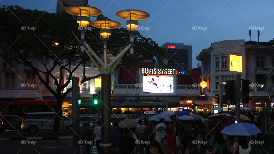 almost 6pm, drizzly, at Bugis Street Singapore, the city lights has conquered completely the sunlight which still remained.