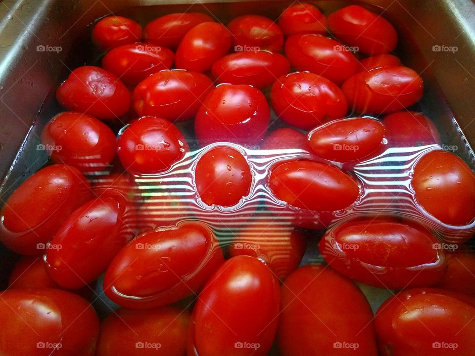 Many Tomatoes Being Rinsed Together
