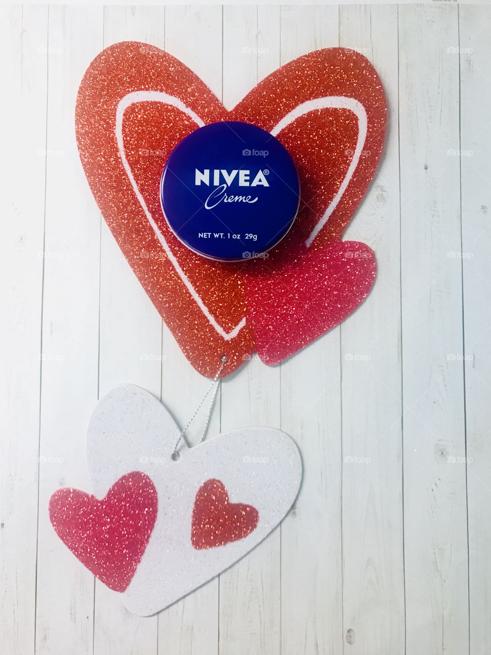 Love is in the air with Nivea cream body moisturizer and lotion against a heart shaped background with glitter representing Valentine’s Day. USA, America