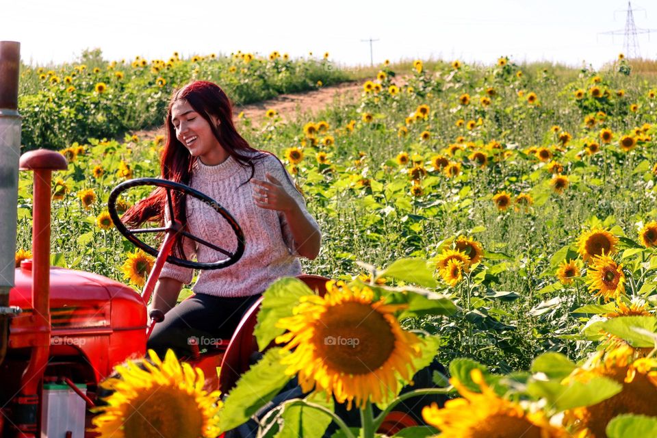 Beautiful young woman in a field of sunflowers