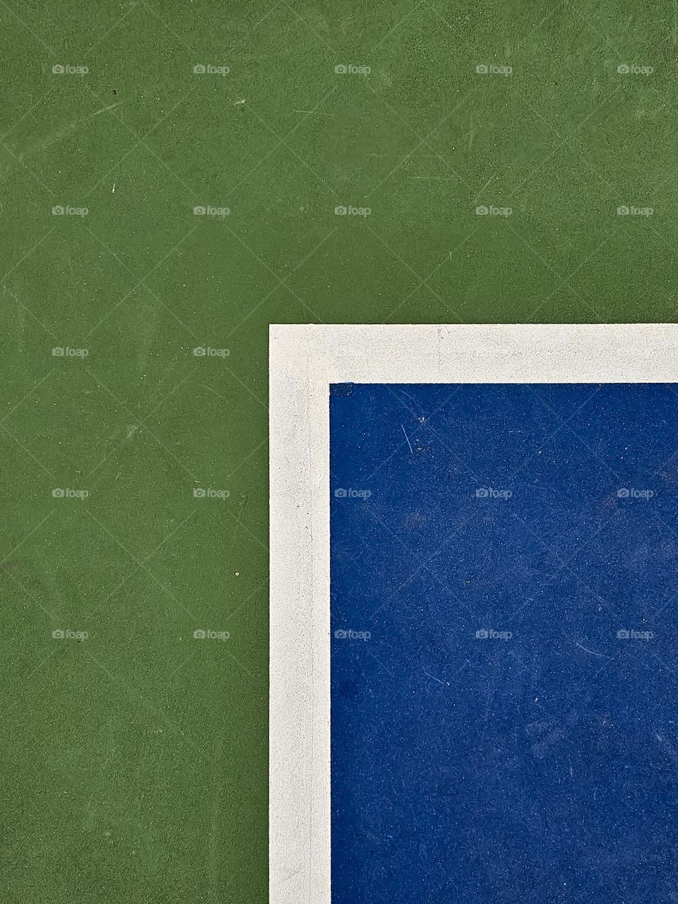 Detail of an outdoor basketball court corner, abstract and modern with the green, blue and white corner 