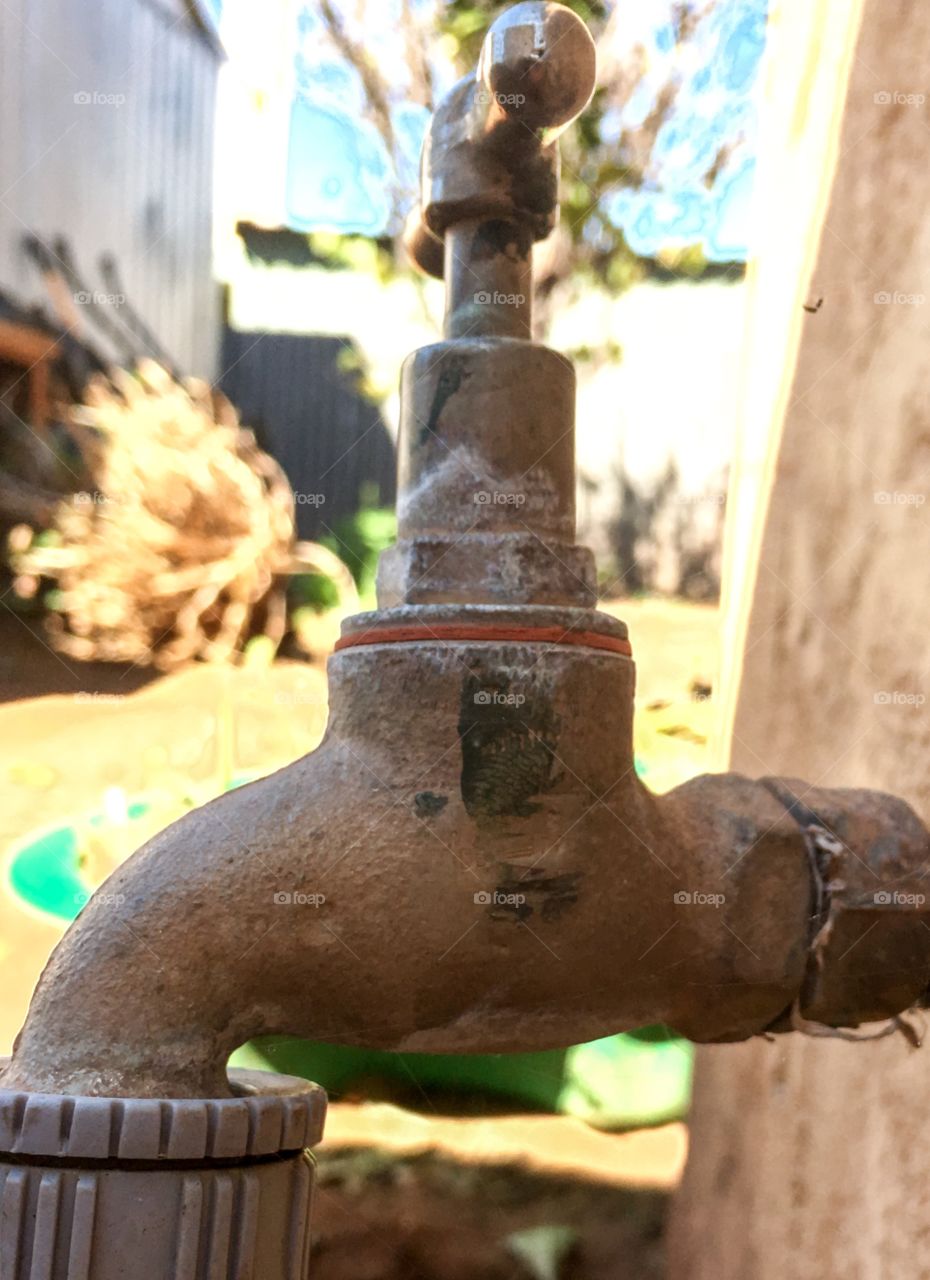 Antique outdoor garden faucet tap closeup with blur background