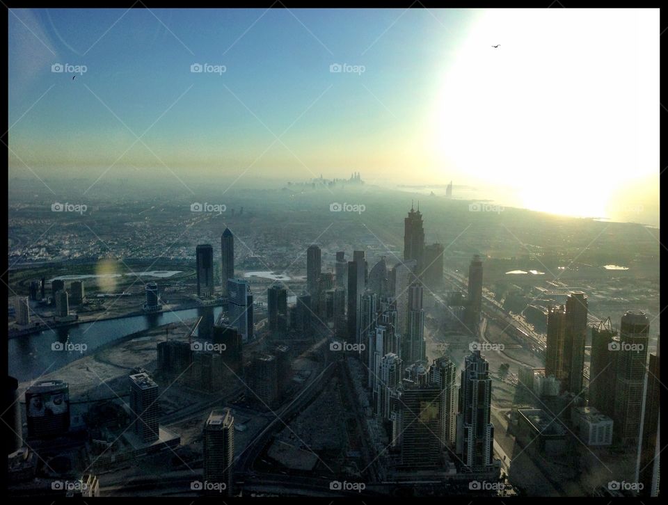 City Skyscape. Dubai skyline with the sun setting over the Persian Gulf