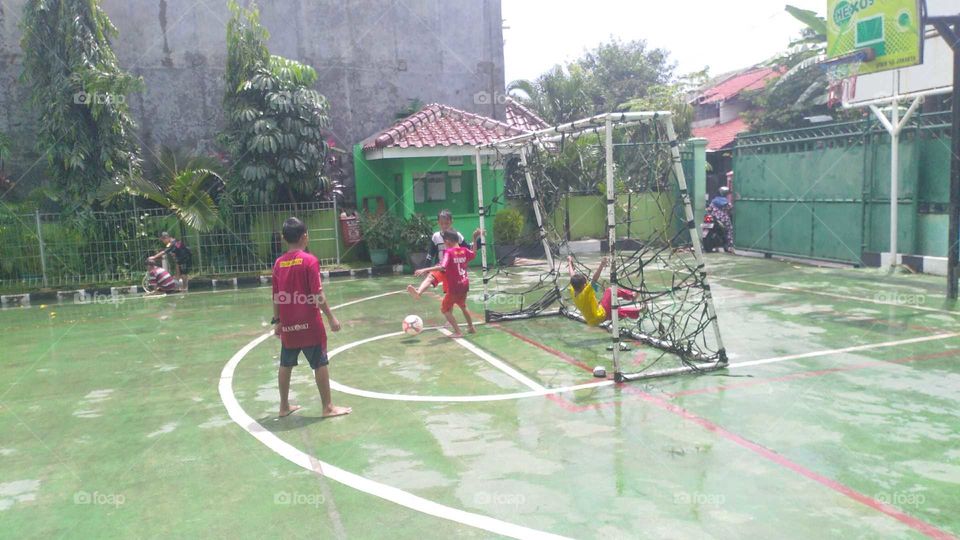 children play football after rain