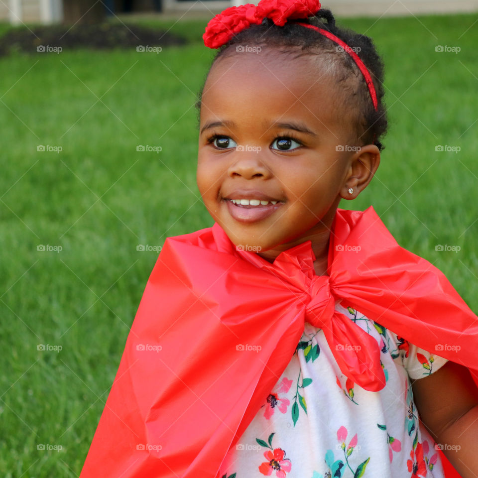 Young girl in red cape smiling