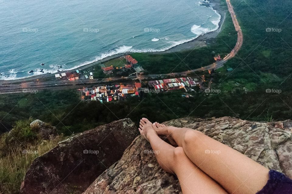 Feet dangle off a cliff in Yilan, Taiwan. 