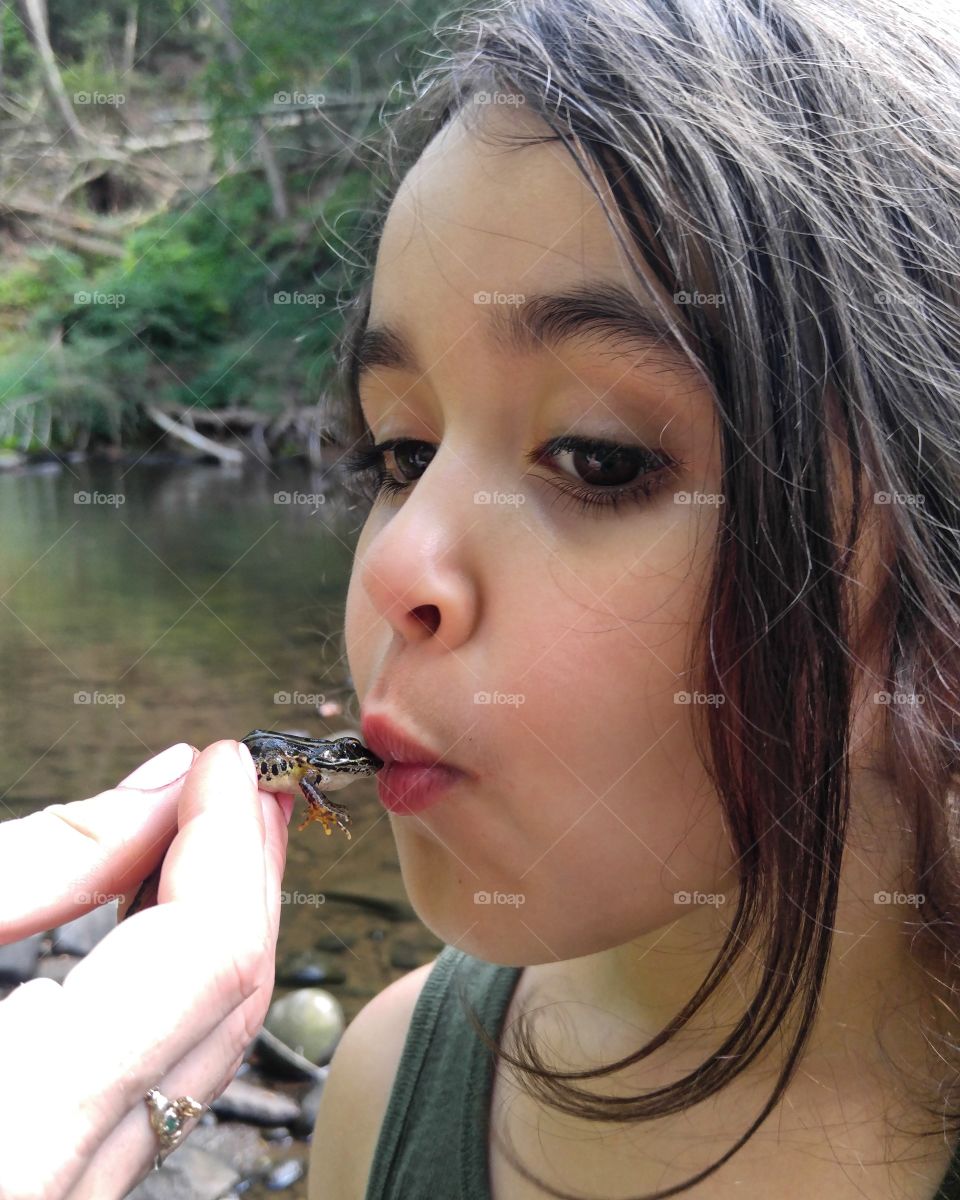 Girl kissing frog
