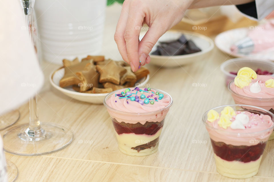 women's hands decorate the dessert in a cup