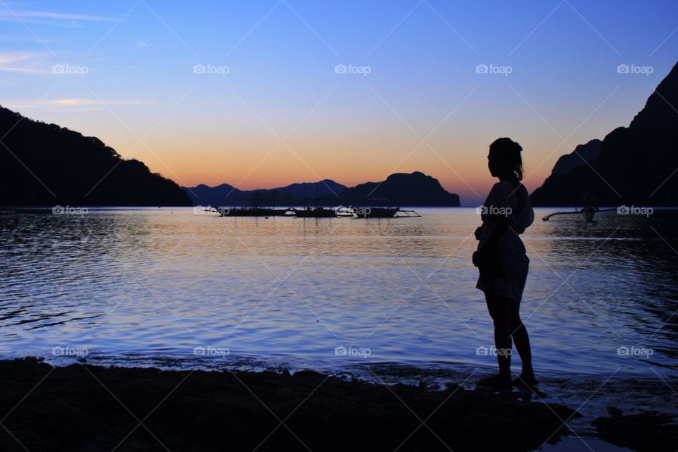 Silhouette of a lady on the beach at dusk