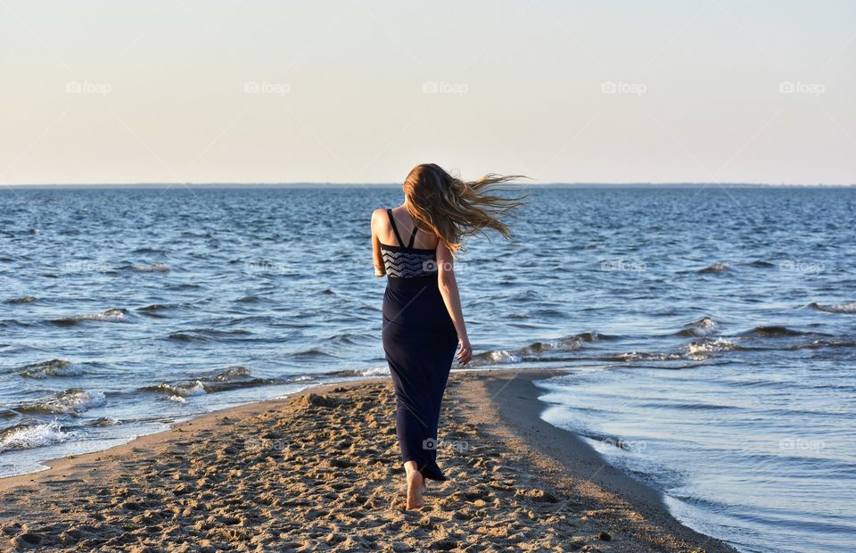 woman walking along the baltic sea in rewa