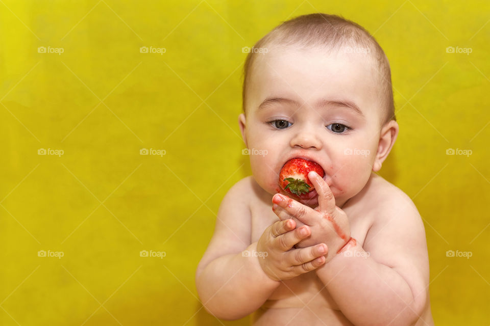boy eating strawberries in summer
