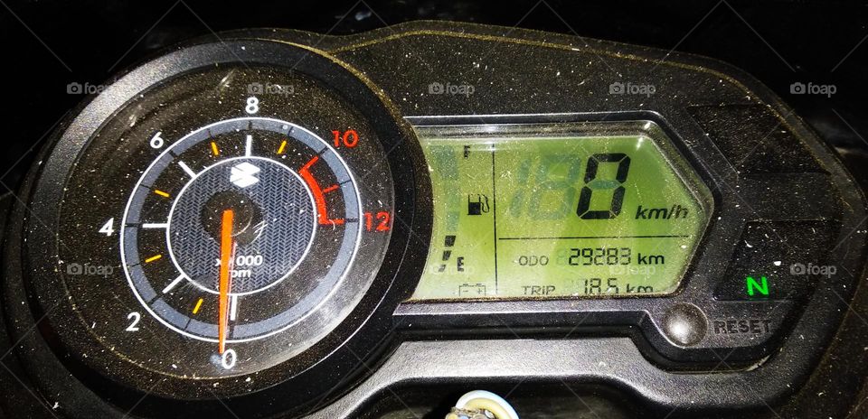 Motorcycle bajaj pulsar speedometer on the way at night.