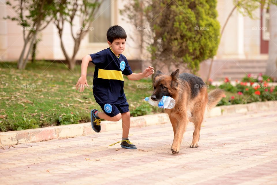 a boy running with his dog