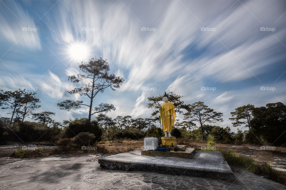 Buddha statue in the forest with moving cloud 