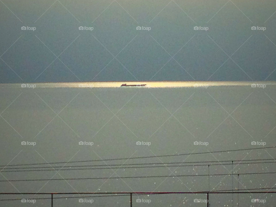 tanker between sea water sun and cloudy on a lake by swisstraveler