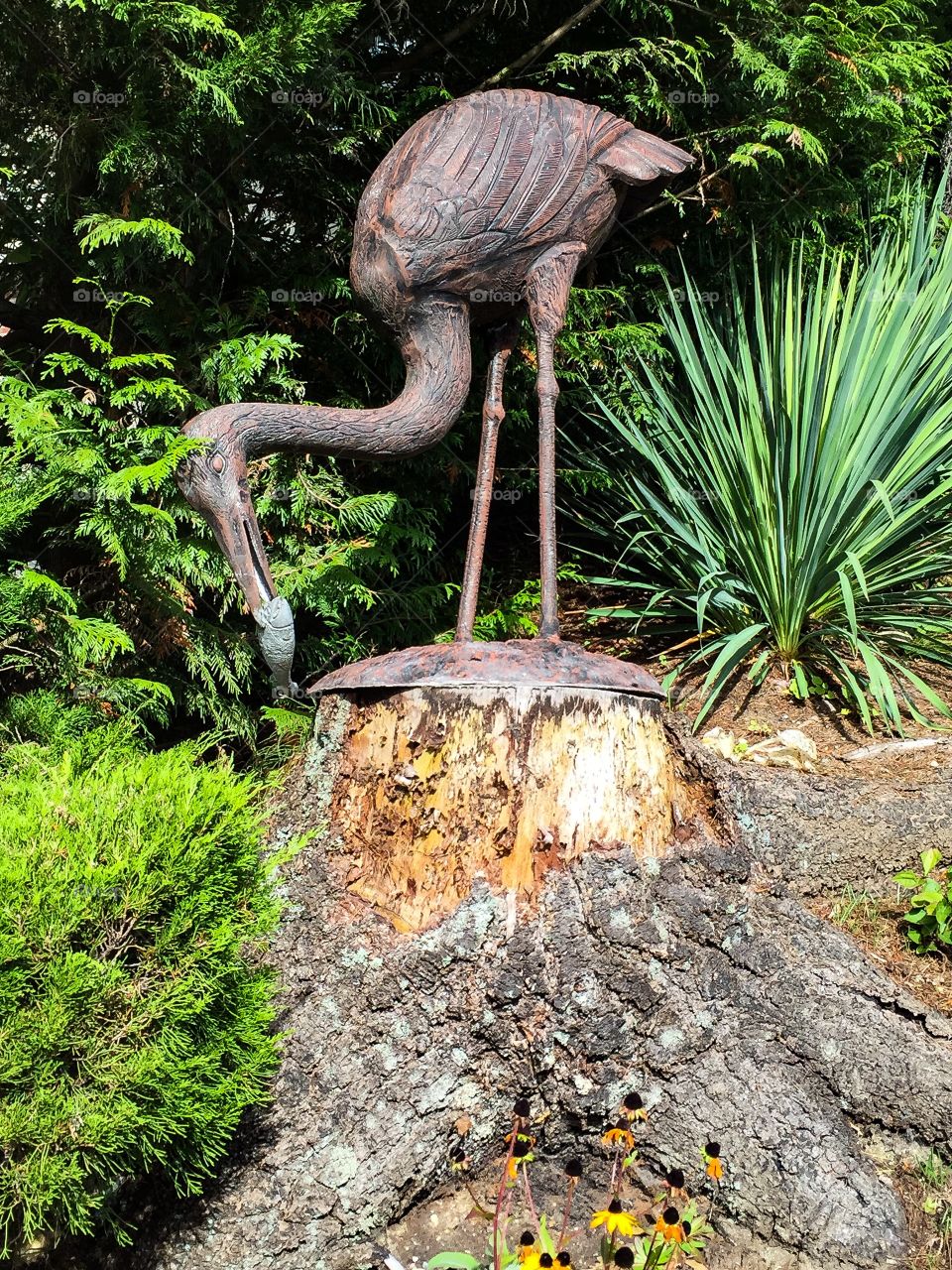 A beautiful metal statue on a Herron and fish 