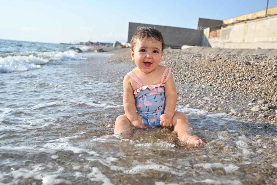 little girl smiling by the sea