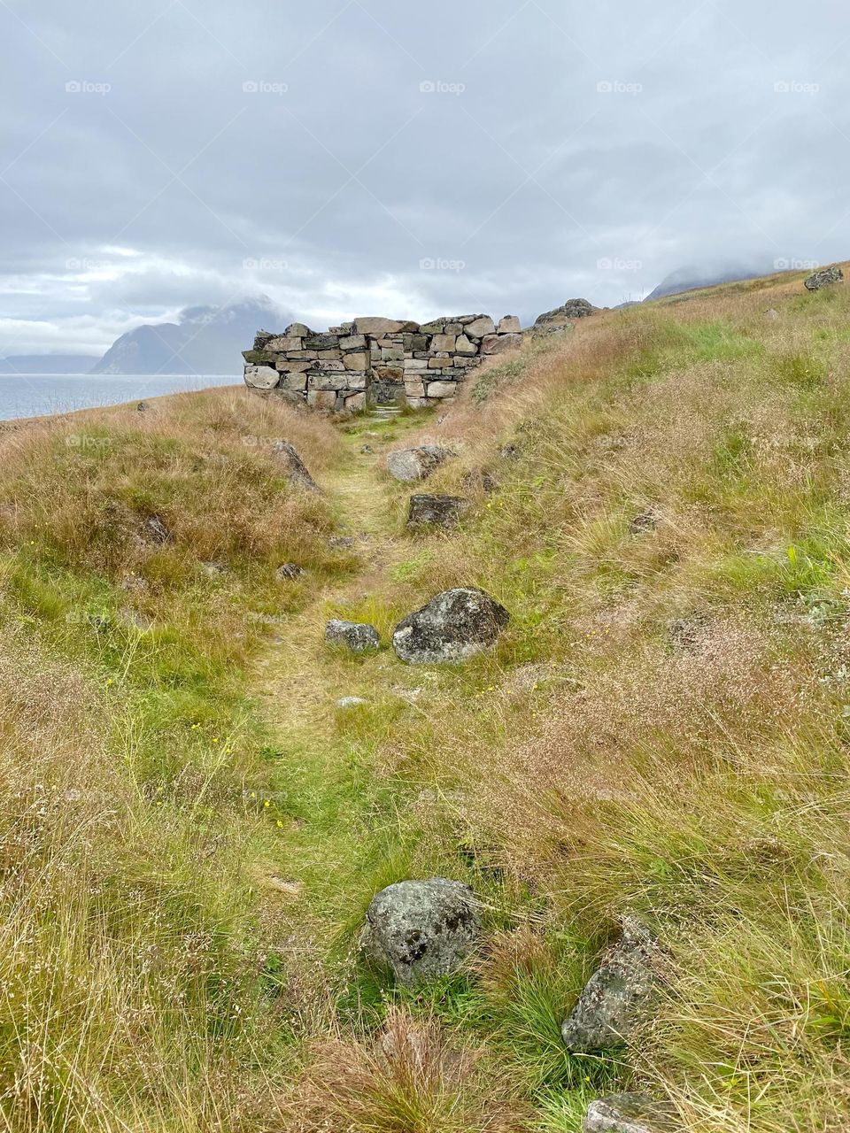 A grassy hill with the remains of a Viking village in the background
