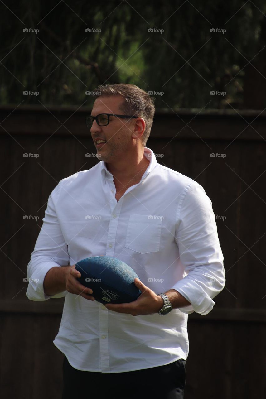 Handsome smiling man holding football