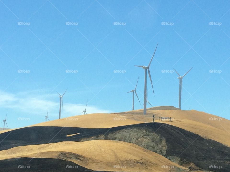 Windmills on layers of yellow and black soil 